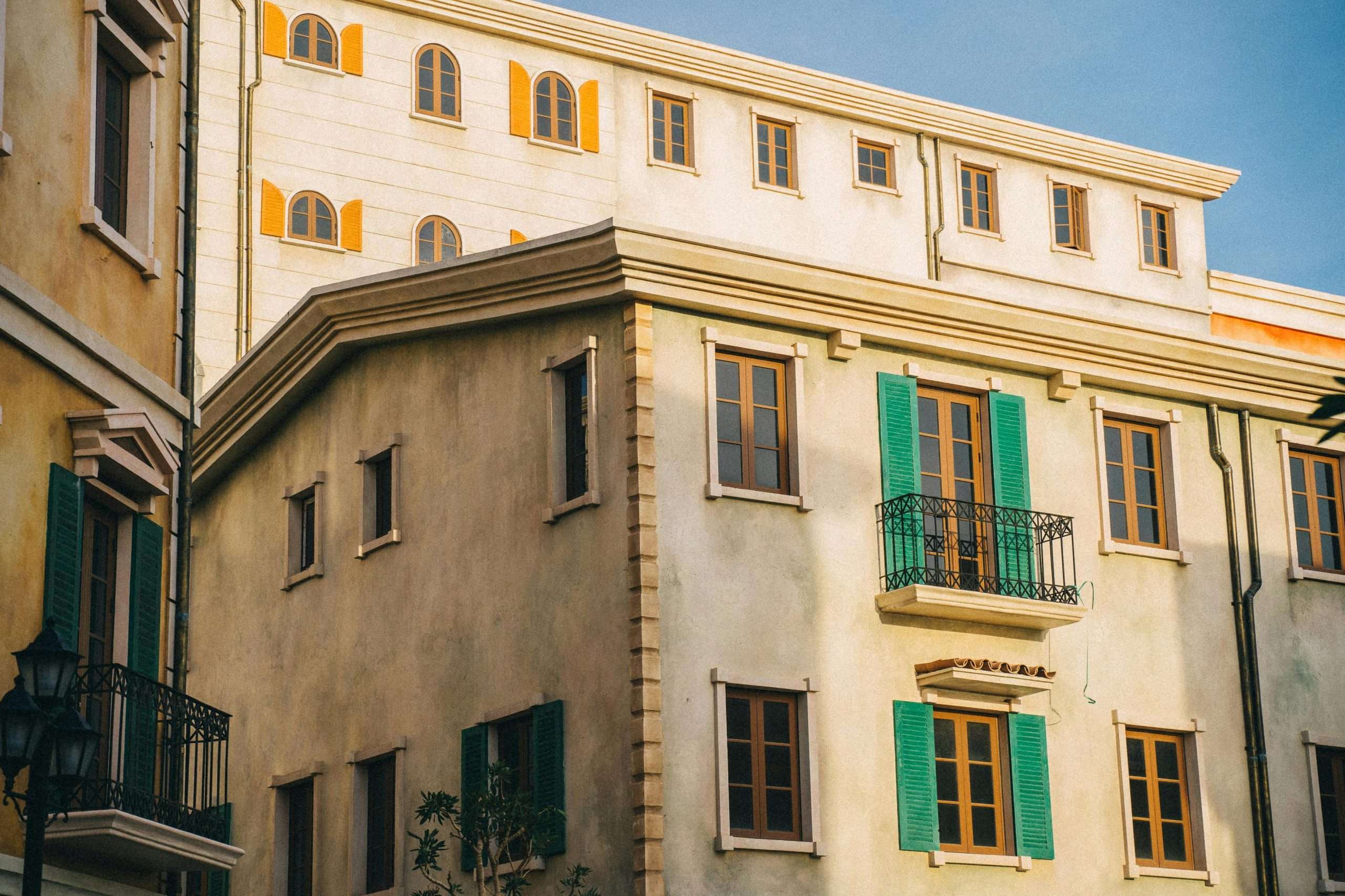 Charming urban architecture with colorful shutters and balconies under a clear blue sky.