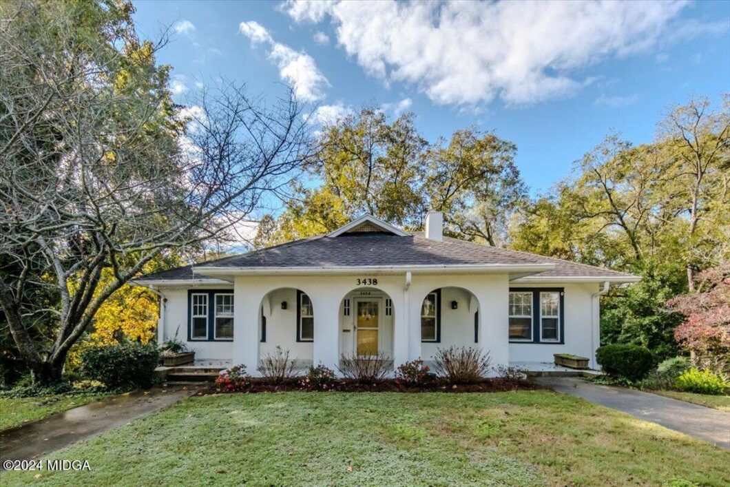 White, single-story house with a curved front porch featuring three arches and the address 3438 on a sunny day.