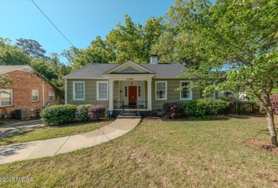 Front view of a single-story olive-green house with white trim, a small front porch, and the number 3280 above the door.