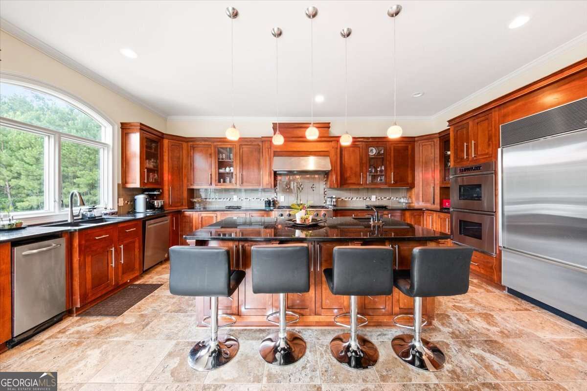 Modern kitchen with a large central island, dark wood cabinets, and stainless steel appliances (real estate photo).”,
