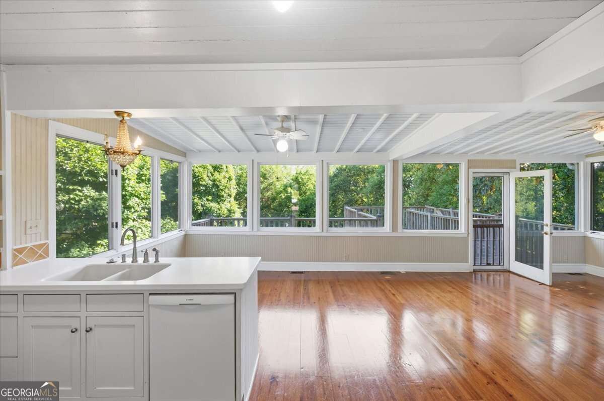 Interior room. Hardwood floors large windows, and door leading to deck.