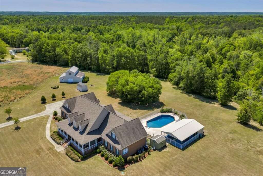 Aerial view of 6605 Britt Road in Macon GA showing the main residence, saltwater pool, barn, and surrounding 35.770 acres of private land in Bibb County.
