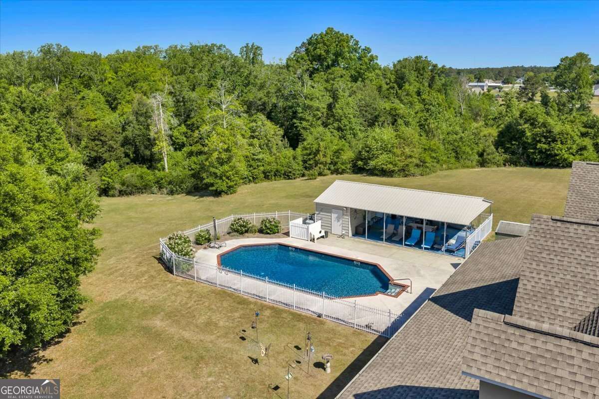 Aerial view of 6605 Britt Road in Macon GA showing the fenced in saltwater pool, pool house, and surrounding 35.770 acres of private land in Bibb County.