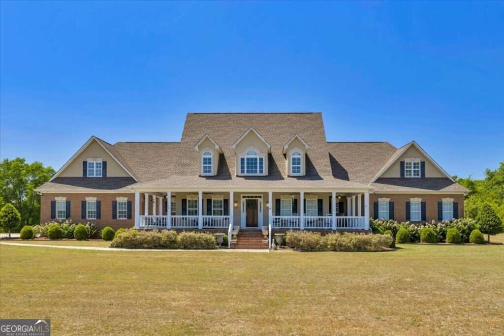 Front view of home showing green grass, and large porches.