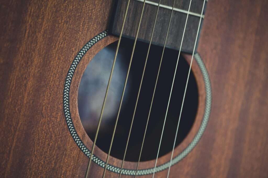 Close-up of an acoustic guitar showing the soundhole, strings, and wood grain.
