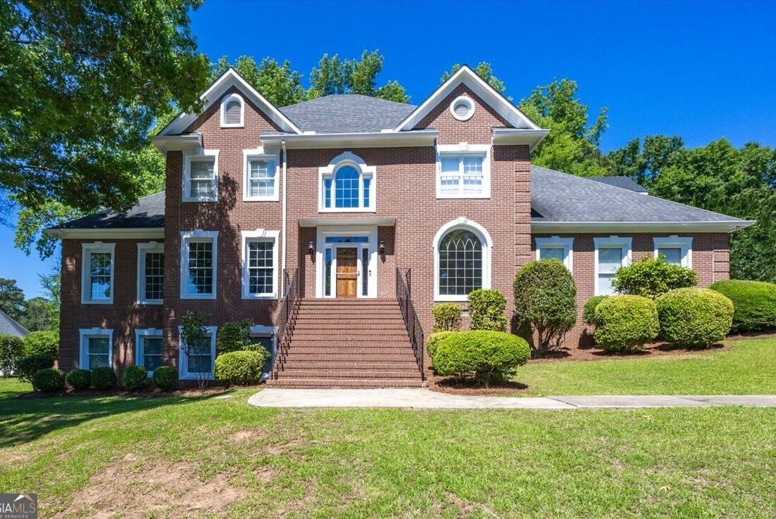 216 Hunters Hill Court Macon, GA 31210 - Joanna "JoJo" Jones - Joanna "JoJo" Jones Front exterior view of 216 Hunters Hill Court in Macon, Georgia featuring stately brick architecture, grand staircase entry, manicured landscaping, and elevated hillside setting in Rivoli Downs.