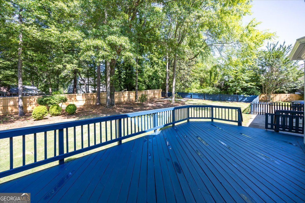 Large outdoor deck at 216 Hunters Hill Court overlooking the fenced backyard with mature trees, landscaped surroundings, and private outdoor entertaining space in Rivoli Downs.