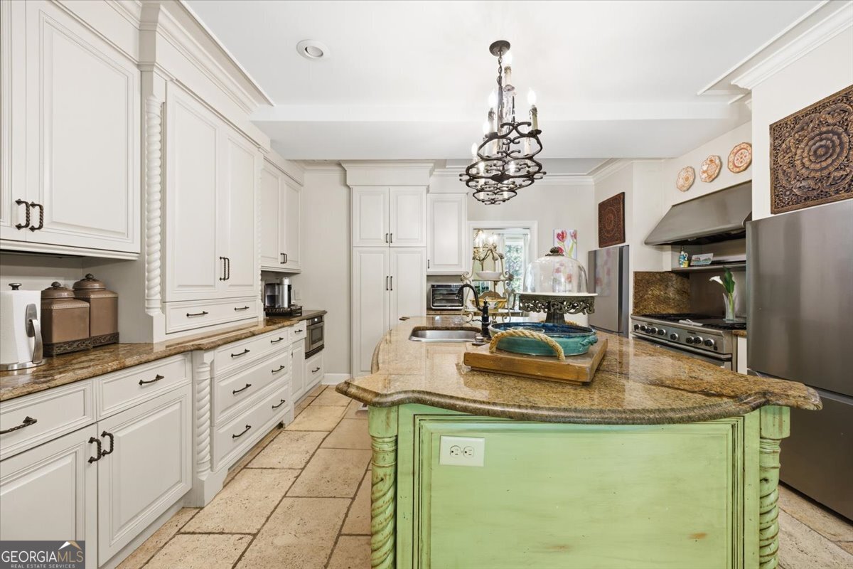 Luxury gourmet kitchen at 4717 Brae Burn Lane featuring custom cabinetry, oversized center island, granite countertops, designer lighting, and elegant high-end finishes in this Saint Andrews luxury home.