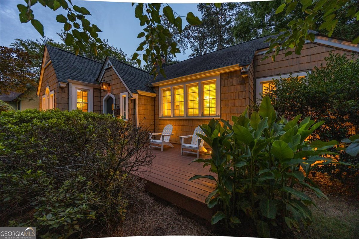 Charming Ingleside home with inviting front porch, warm evening lighting, mature landscaping, and classic architectural details in Macon, Georgia