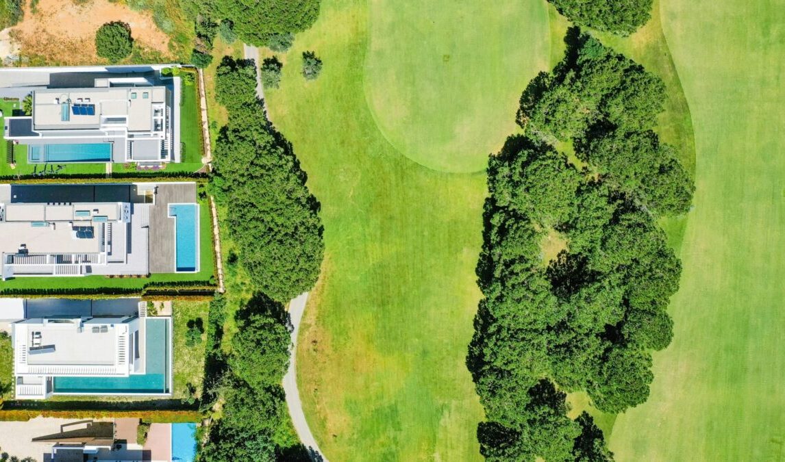 Luxury Homes and Open Green Space - Joanna "JoJo" Jones Aerial view of upscale residential properties featuring modern homes, private pools, and open green space.