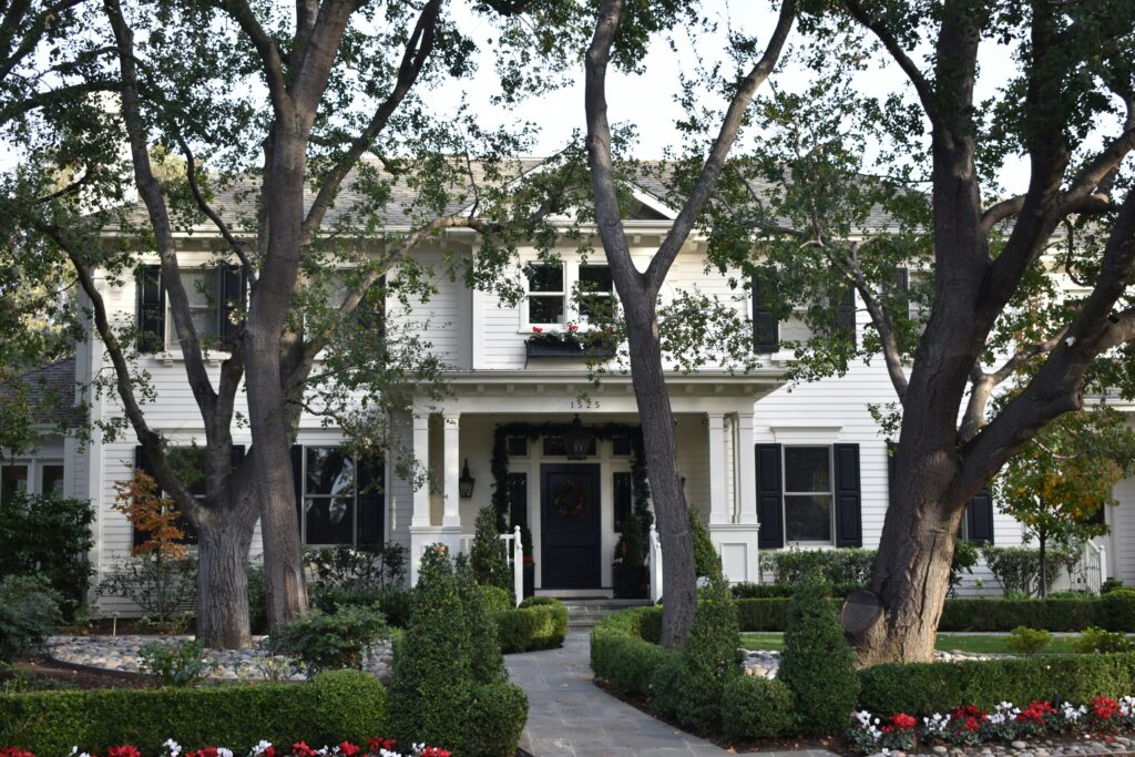 Well-maintained two-story home with mature trees, landscaped yard, and inviting front entrance in a residential neighborhood.