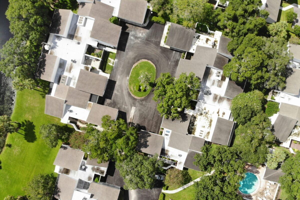 Searching for Homes in Growing Communities - Joanna "JoJo" Jones Aerial view of a residential housing community with homes, landscaped grounds, and neighborhood amenities.