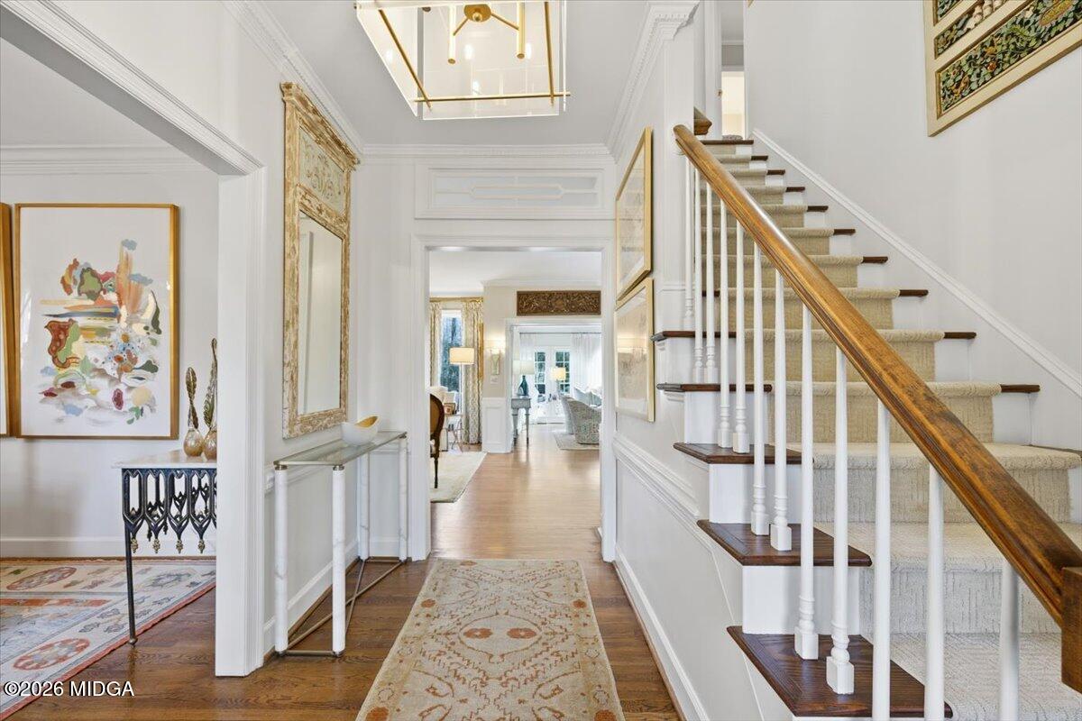 Elegant two-story foyer with hardwood floors, grand staircase, detailed millwork, and refined finishes in a luxury Macon home