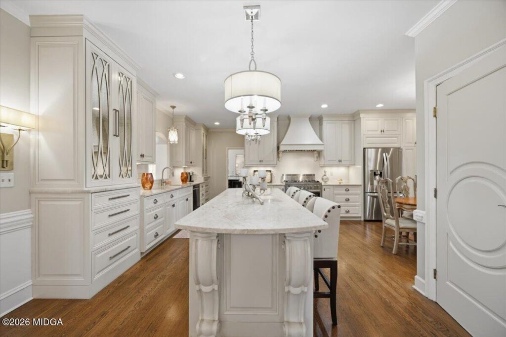 Luxury gourmet kitchen with a large marble island, custom cabinetry, premium appliances, and hardwood floors at 102 Merion Park in Macon, GA