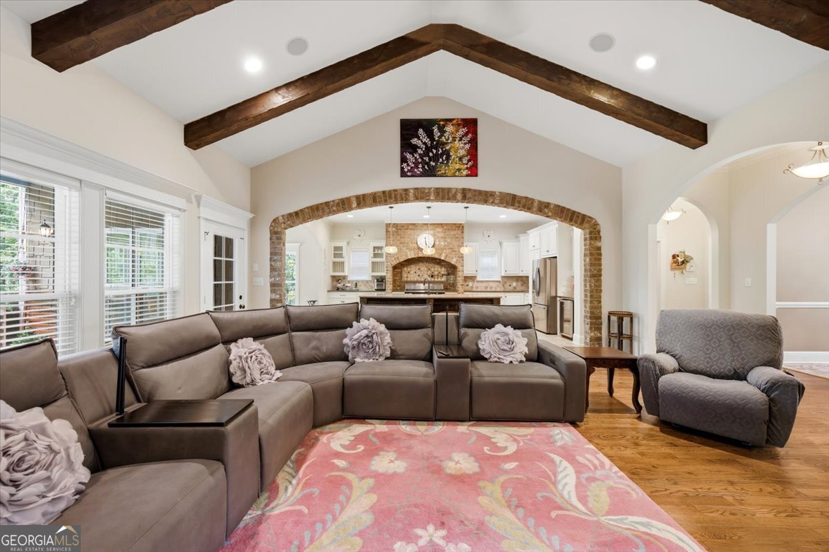 Spacious great room at 309 Heydon Court in Camden North featuring soaring beamed ceilings, hardwood floors, open-concept living, and views into the gourmet kitchen.