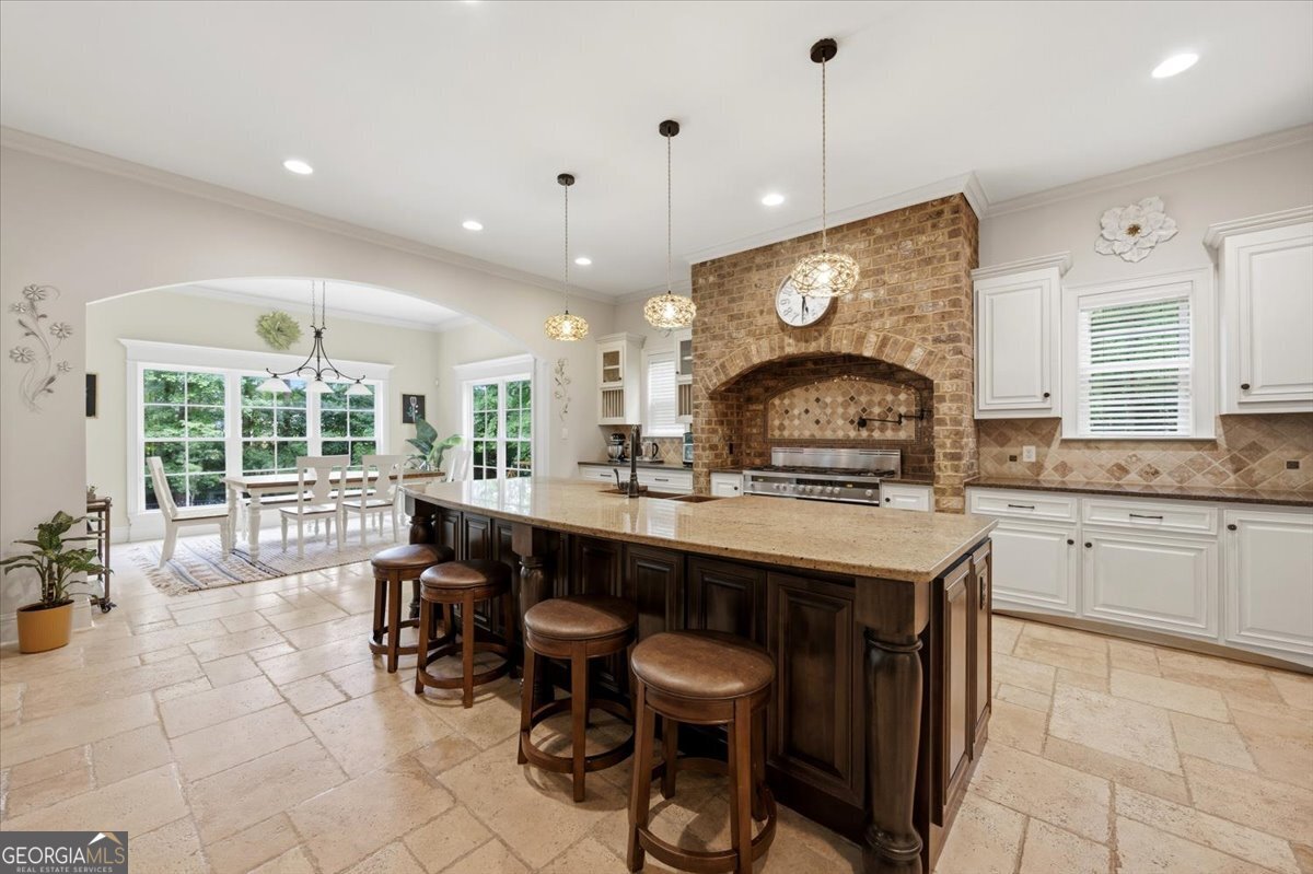 Gourmet kitchen at 309 Heydon Court in Camden North featuring a large center island, custom cabinetry, brick cooking alcove, breakfast area, and open-concept design.