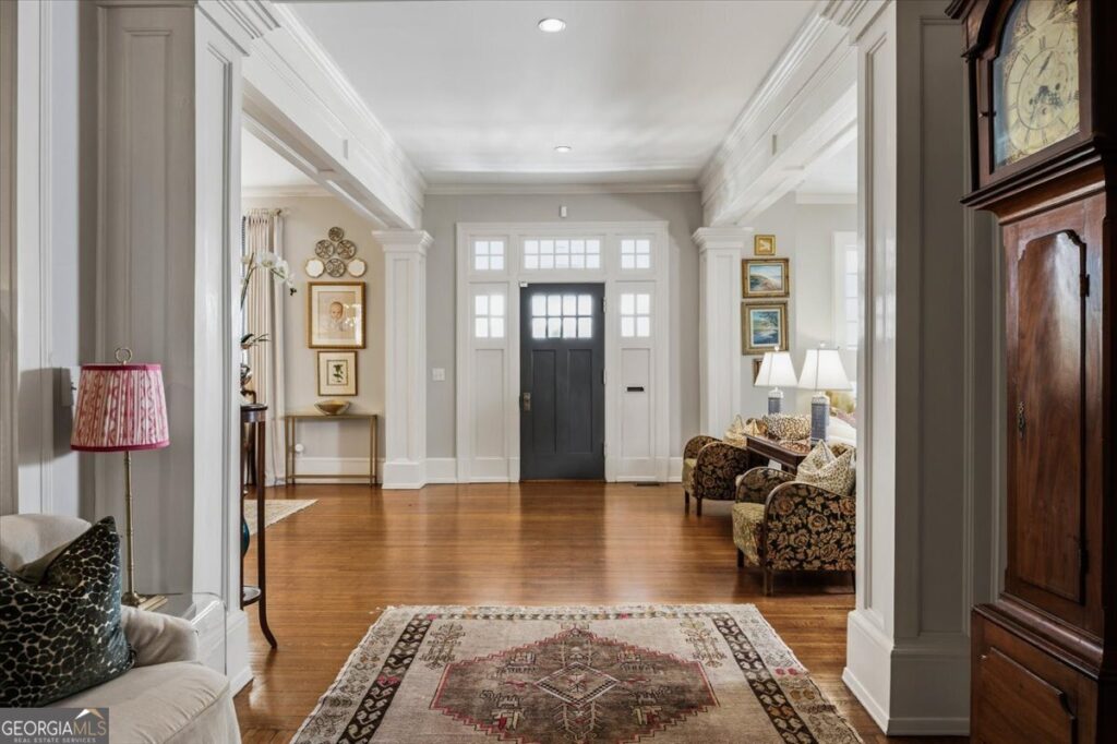 Grand foyer of a renovated Ingleside Midtown home featuring soaring ceilings, hardwood floors, elegant columns, abundant natural light, and classic architectural details.