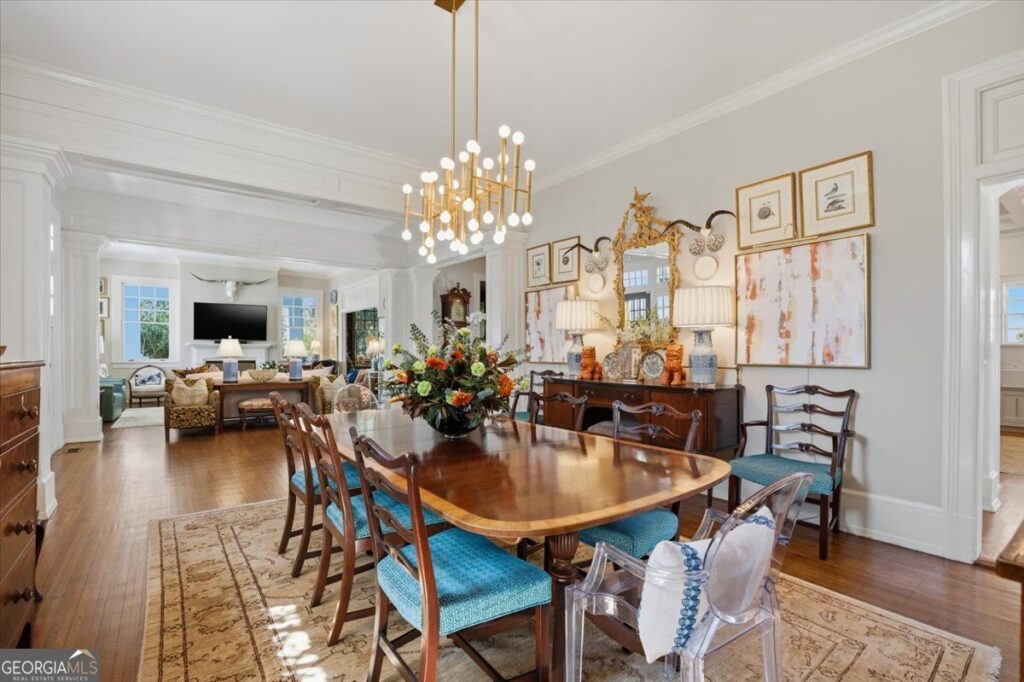 Elegant formal dining room with hardwood floors, designer lighting, custom millwork, and an open layout that flows seamlessly into the spacious living area of this Ingleside Midtown home.