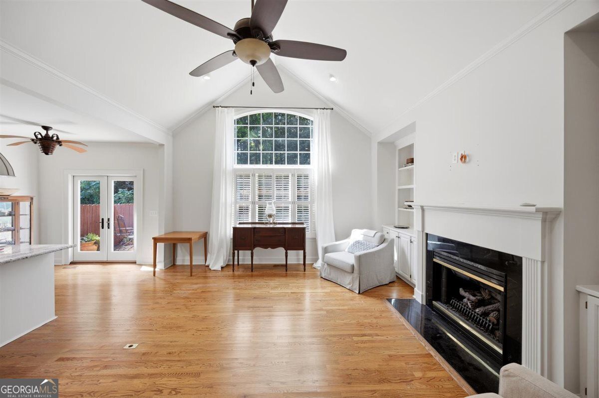 Great Room with Vaulted Ceilings & Fireplace | 155 N. Wellington, North Macon - Joanna "JoJo" Jones Spacious great room at 155 N. Wellington featuring vaulted ceilings, hardwood floors, a fireplace, built-in shelving, and abundant natural light.