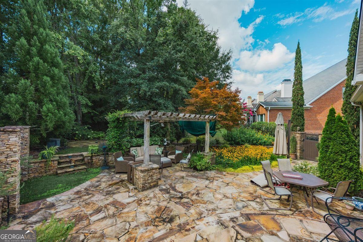 Private Flagstone Patio & Landscaped Backyard | 155 N. Wellington, North Macon - Joanna "JoJo" Jones Flagstone patio with pergola, landscaped garden, and private fenced backyard at 155 N. Wellington in the Wellington Subdivision, North Macon.
