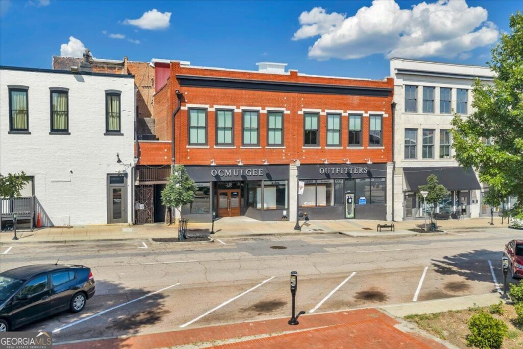 Exterior of 565 Poplar Street in Macon, GA, featuring a historic two-story brick building with street-level commercial space and upper-level residences.