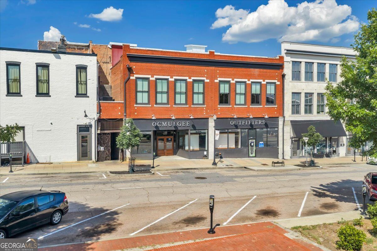 Exterior of 565 Poplar Street in Macon, GA, featuring a historic two-story brick building with street-level commercial space and upper-level residences.