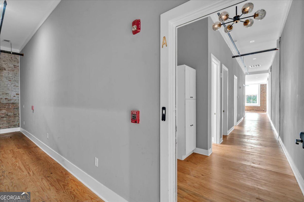 Entrance to Unit A at 565 Poplar Street in Macon, GA, featuring hardwood floors, high ceilings, modern lighting, and a renovated residential interior.