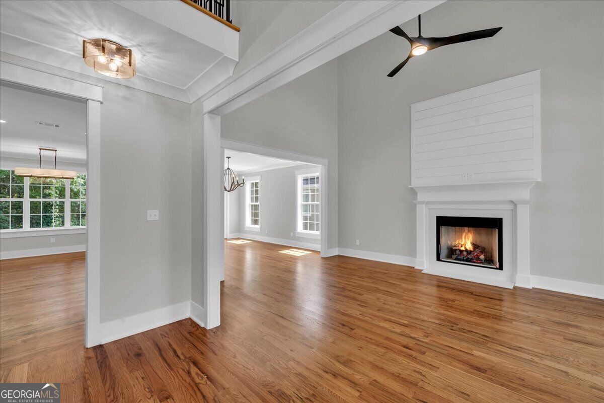 Living room at 203 Oberon Place N in Macon, GA, featuring hardwood floors, high ceilings, a fireplace, ceiling fan, and open layout.