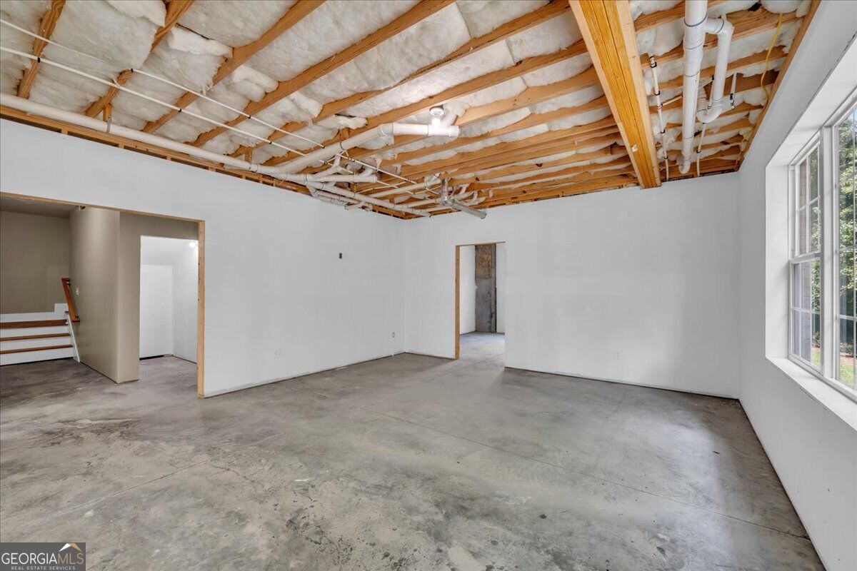 Unfinished daylight basement at 203 Oberon Place N in Macon, GA, featuring concrete floors, windows, and open space with potential for future finishing.
