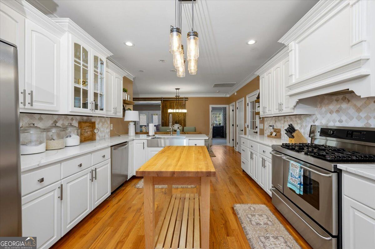 Bright kitchen with white cabinetry and stainless steel appliances
