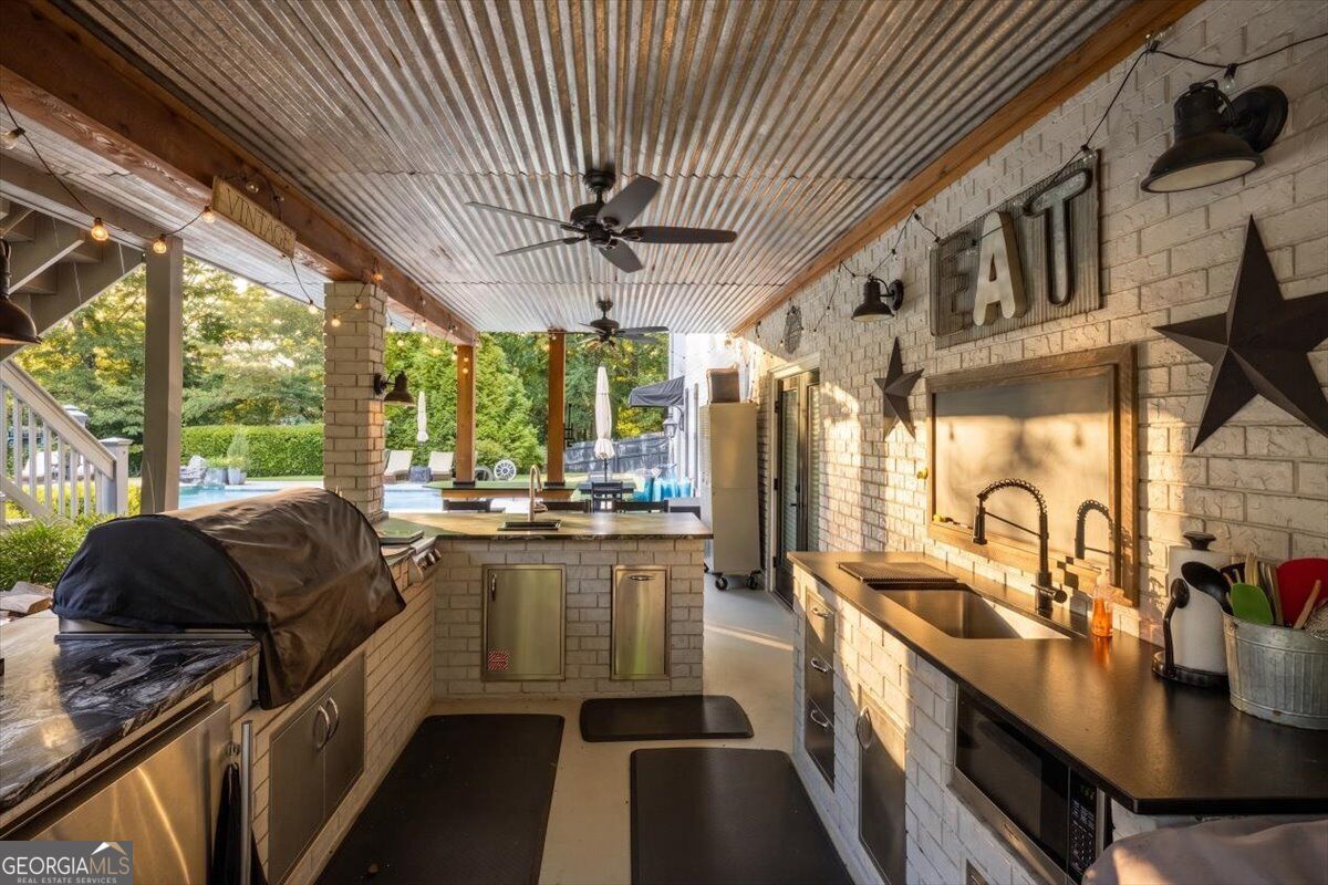 Covered outdoor chef’s kitchen overlooking the pool