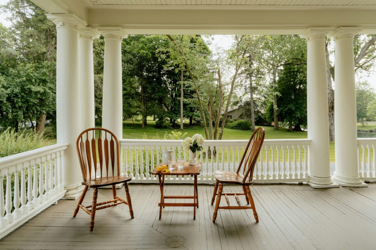 Front Porch Lifestyle for Home Buyers - Joanna "JoJo" Jones - Joanna "JoJo" Jones Inviting front porch with seating overlooking a peaceful green yard