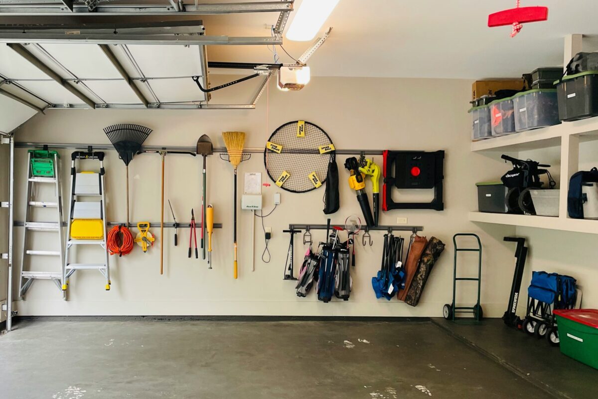 Organized Garage Storage for Home Buyers - Joanna "JoJo" Jones - Joanna "JoJo" Jones Organized residential garage with wall-mounted tools, shelving, and storage