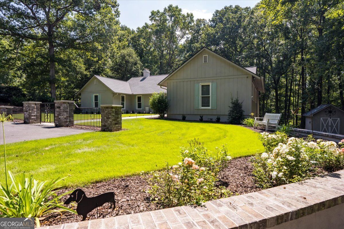 Front exterior with landscaped lawn, flower beds and gated driveway at 4978 Wellington Drive