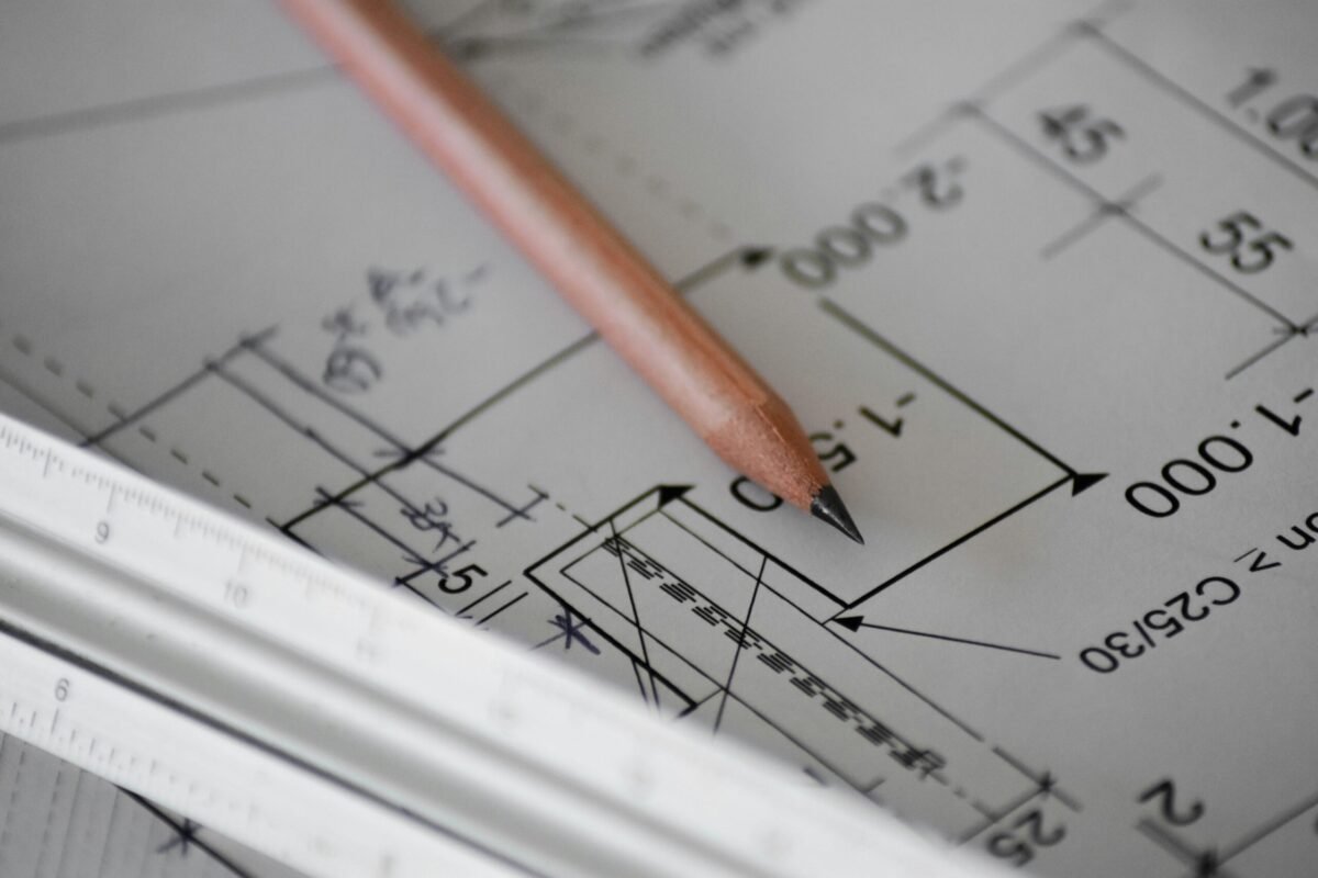 Architectural floor plan with pencil and ruler illustrating how to read home plans and room measurements