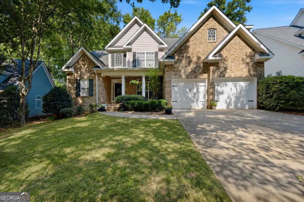 Brick home with a covered front porch and two-car garage at 920 Huntcliffe Drive in Macon’s Providence neighborhood.