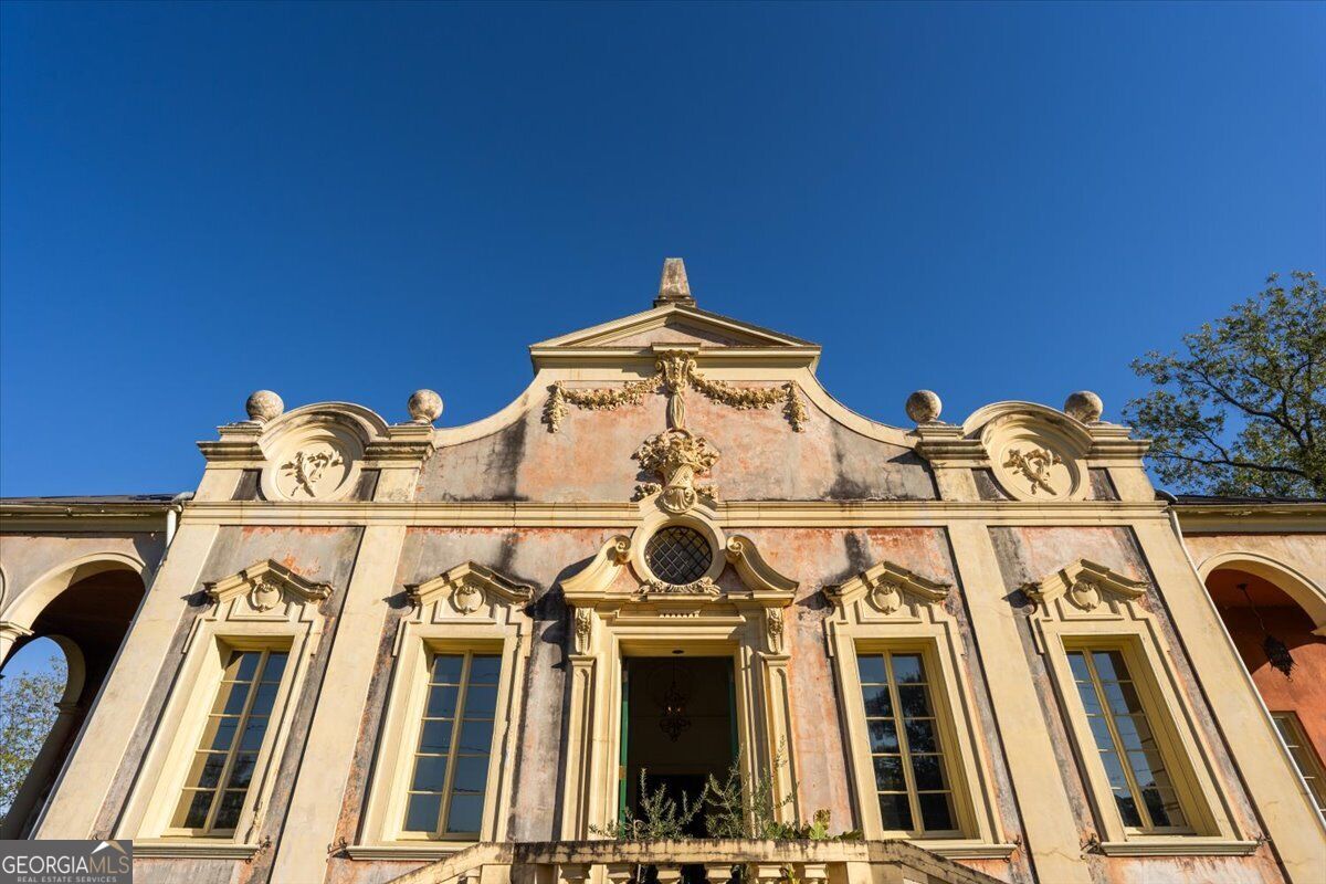 Ornate Italian Baroque facade of Villa Albicini at 150 Tucker Road in Macon GA, featuring sculptural details, decorative window surrounds and a central entrance.