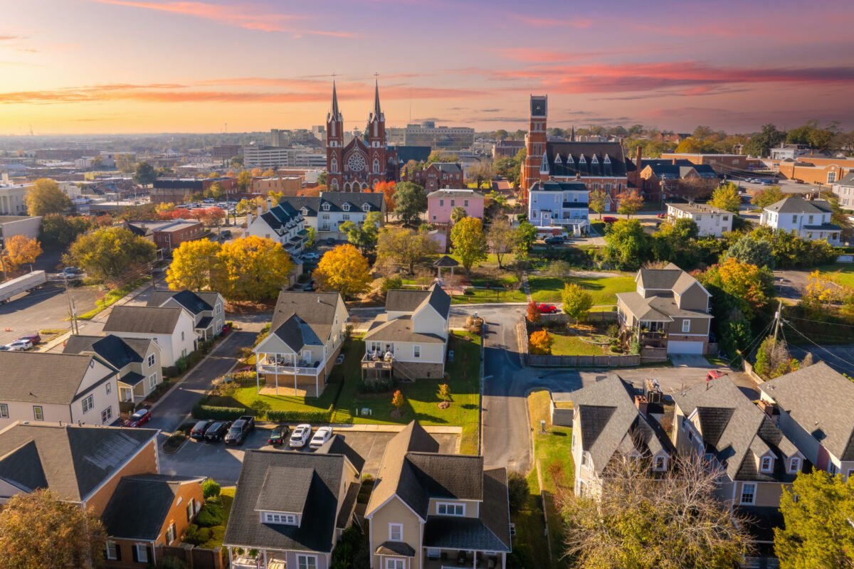 Macon, Georgia Homes and Historic Downtown Skyline - Joanna "JoJo" Jones - Joanna "JoJo" Jones Aerial view of Macon, Georgia, with homes, historic church spires and autumn trees beneath a colorful sky.